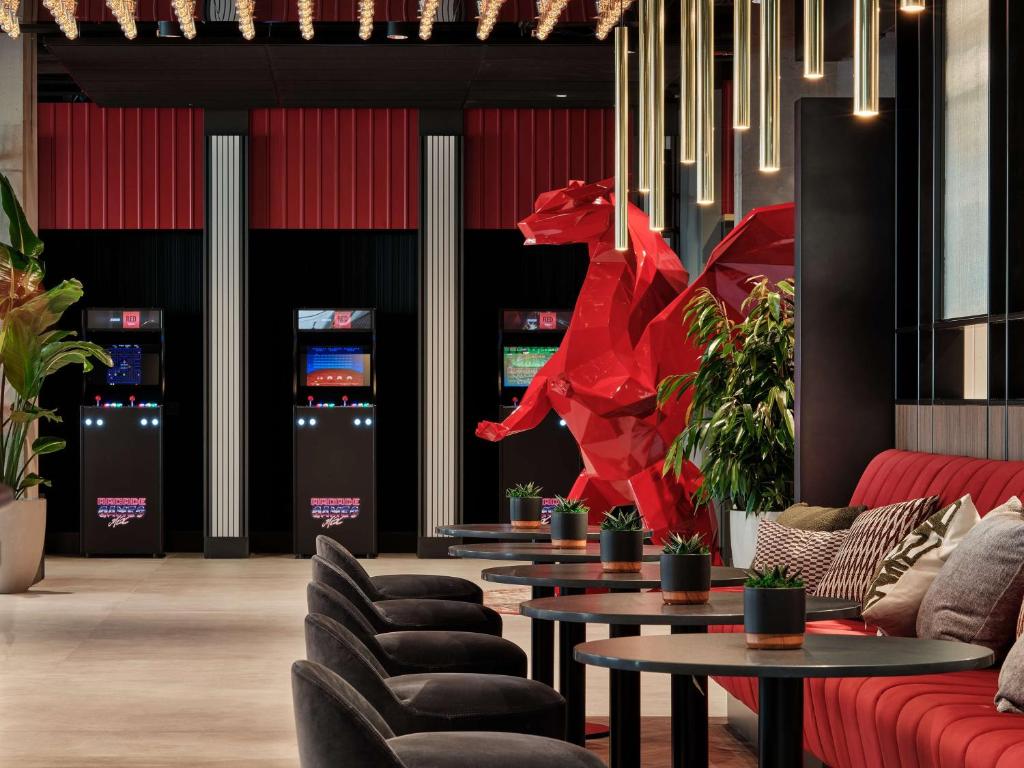 クラクフにあるRadisson RED Hotel & Radisson RED Apartments, Krakówの赤い彫刻が飾られたロビー(ソファ、テーブル付)