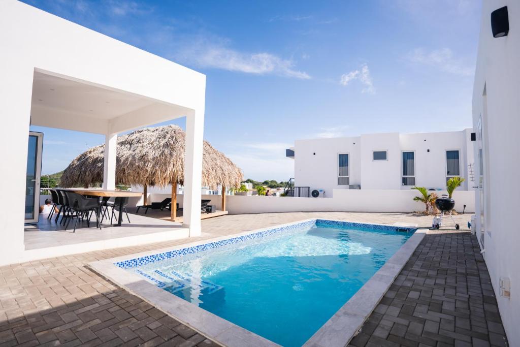 a villa with a swimming pool and a patio at 'Casa 30' Villa nearby Mambo-Beach in Willemstad