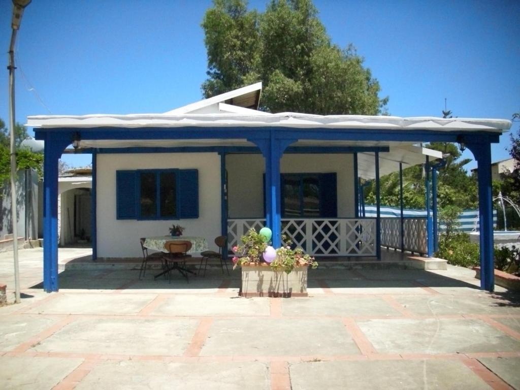 Villetta Mare في Terrauzza: منزل بسقف ازرق وفناء