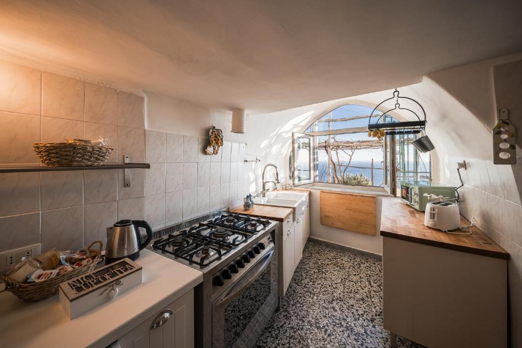 a kitchen with a stove top oven next to a window at Villa Don Luigi in Furore