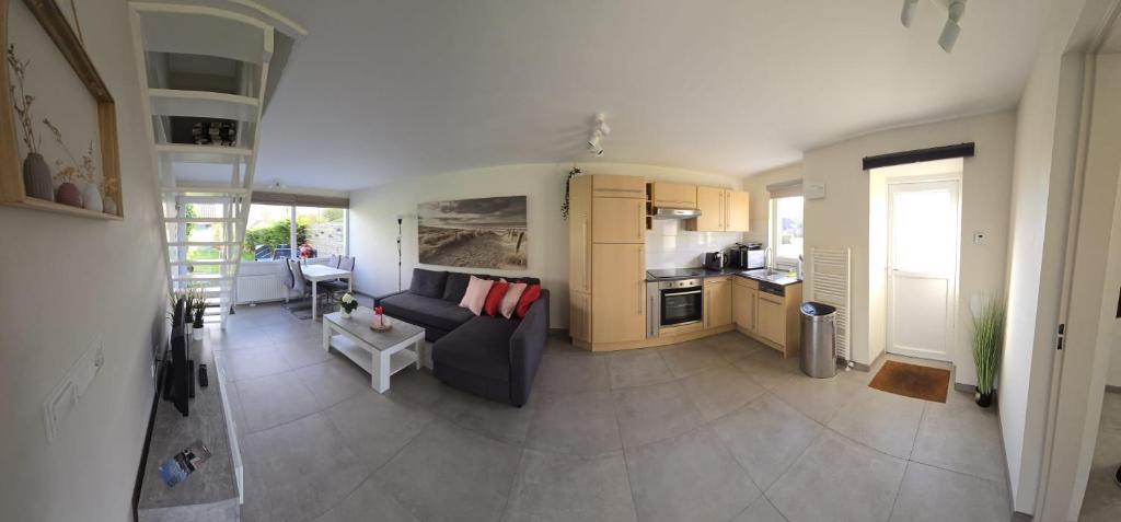 un soggiorno con divano e cucina di De Mossel 147 a Bruinisse