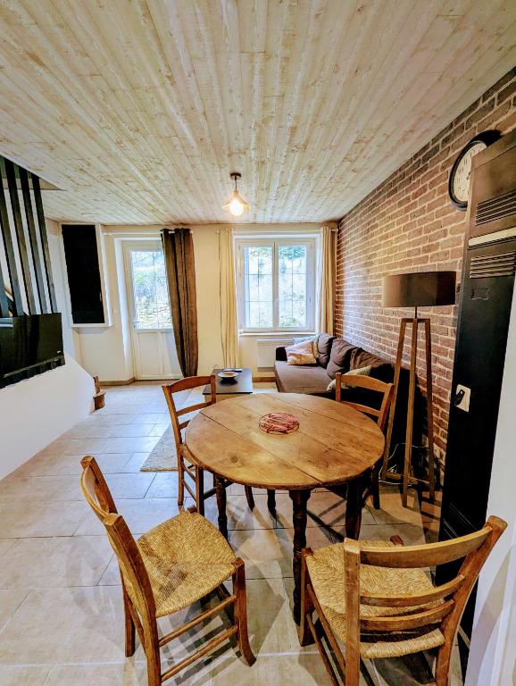 un salon avec une table et des chaises en bois dans l'établissement Au fil de la Cisse, à Molineuf