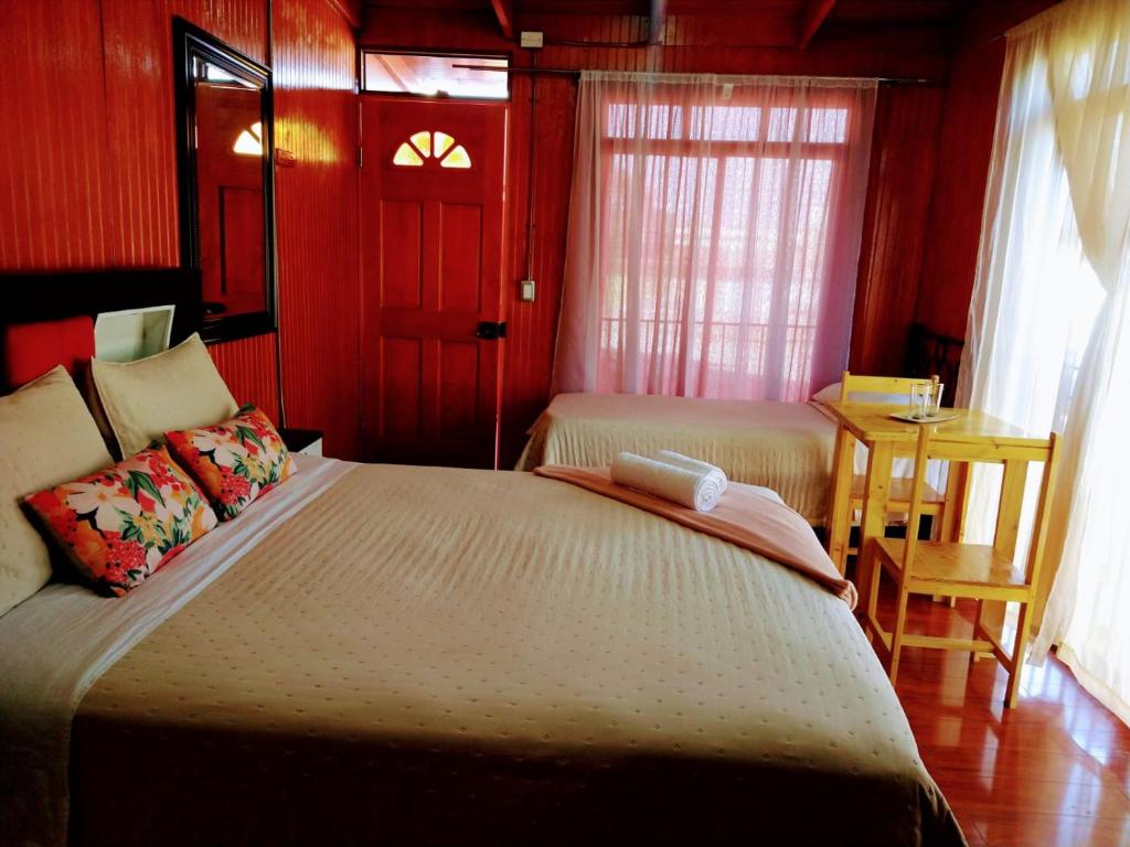 a bedroom with a bed and a table and window at Bercy in Arica