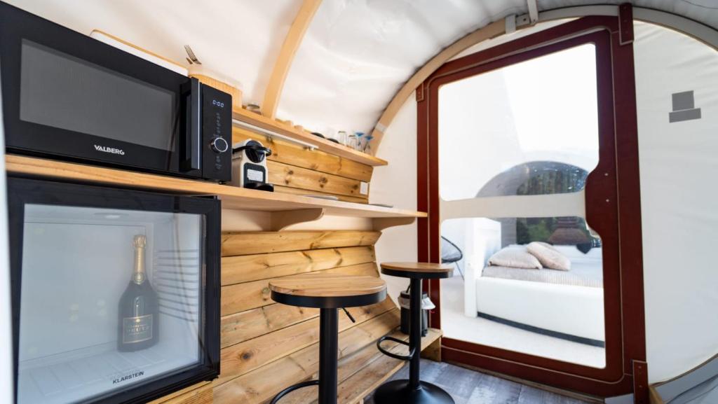 ein Wohnzimmer in einem winzigen Haus mit einem Fernseher in der Unterkunft Bubblesuite47 in Précy-sur-Oise