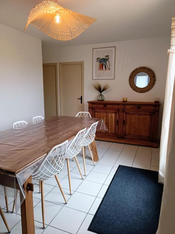 une salle à manger avec une table et des chaises en bois dans l'établissement Maison familiale à 600m de la plage 8mn à pieds, à Saint-Vincent-sur-Jard