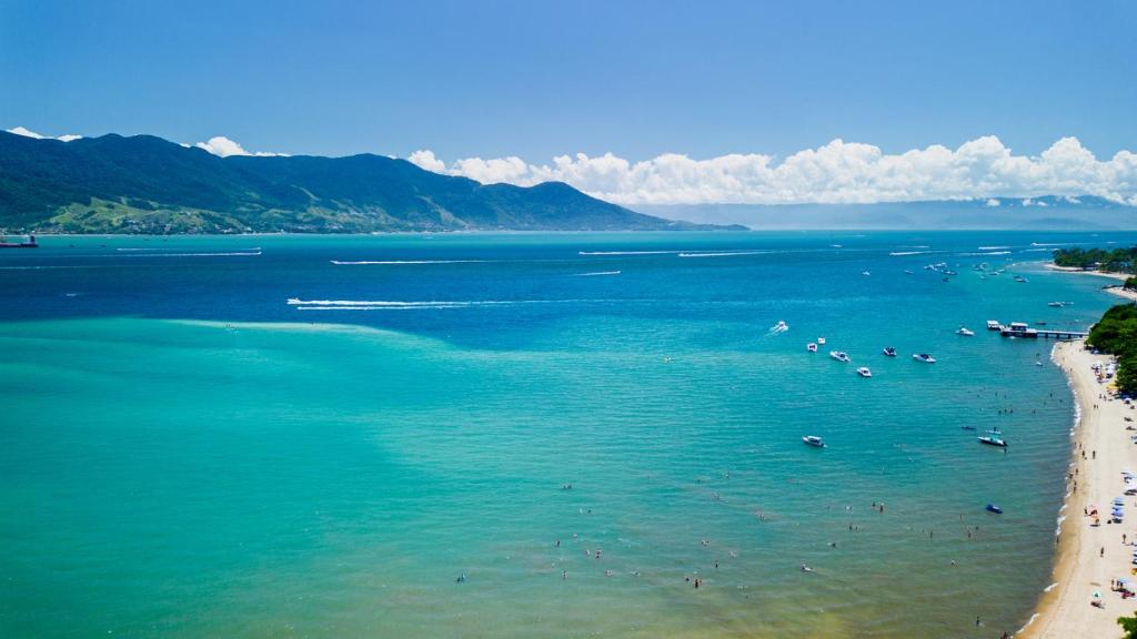 a view of a beach with people in the water at Casa com otima localizacao e churrasqueira in Ilhabela