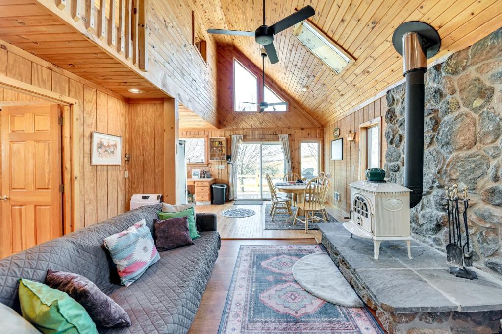 - un salon avec un canapé et une cuisinière dans l'établissement 3 Mi to Catskill Trail Stamford Cottage with Views, à Stamford