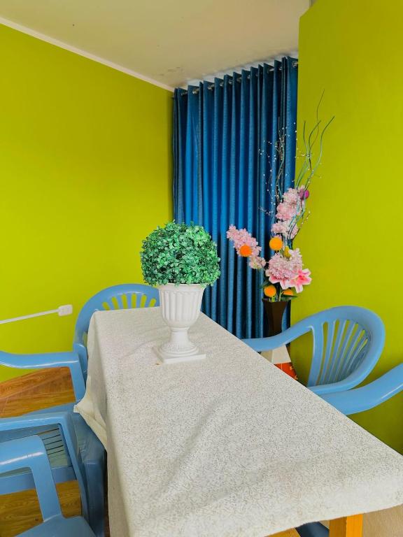 a dining room table with a vase with flowers on it at Departamento con baño privado in Ayacucho