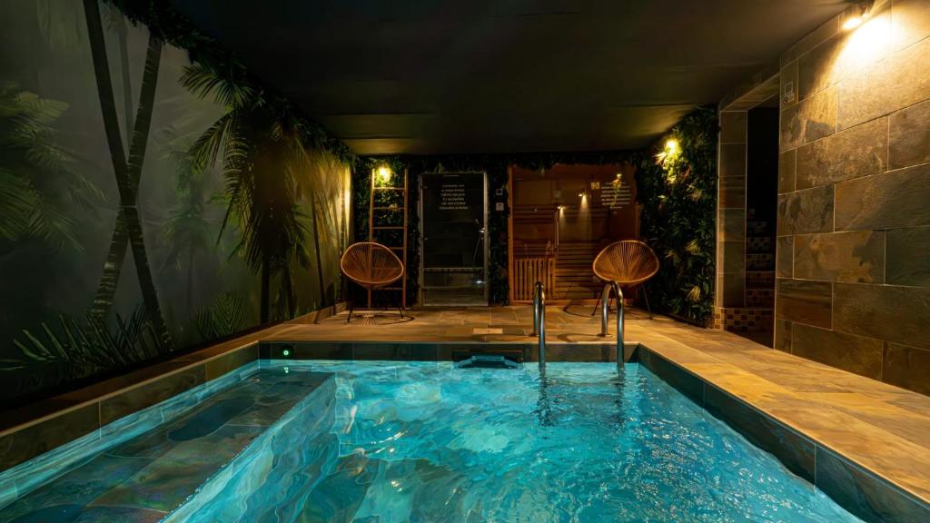 a hot tub in a room with two chairs at Pool47spa in Précy-sur-Oise