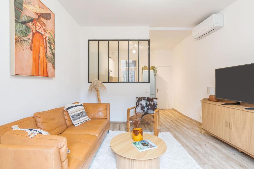 un salon avec un canapé et une télévision dans l'établissement T3 proche cardeurs clim centre ville, à Aix-en-Provence