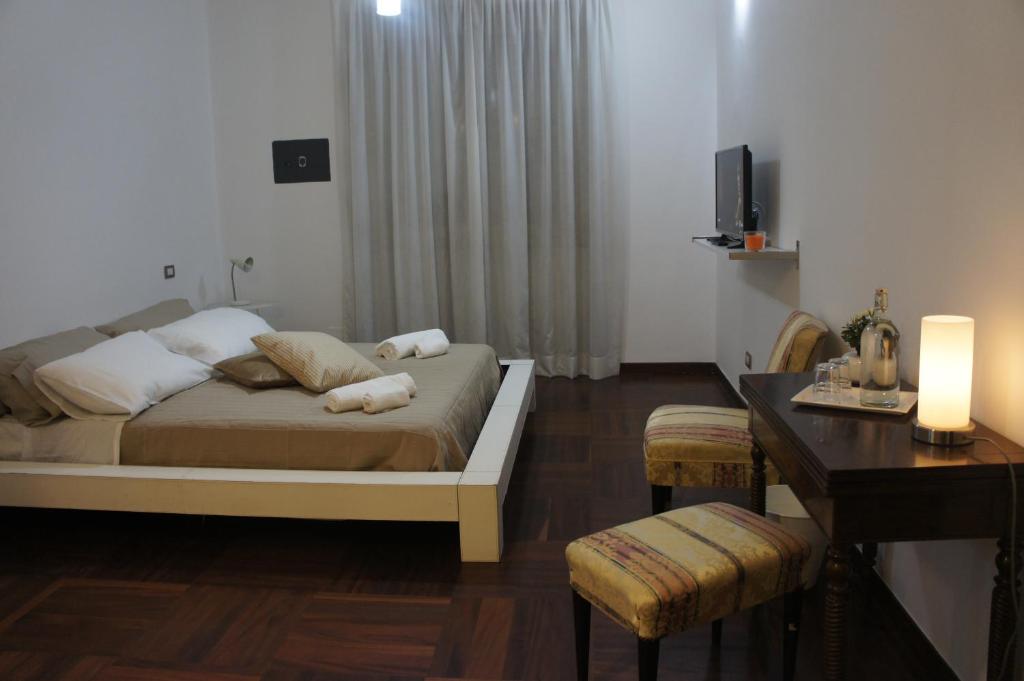 sypialnia z łóżkiem, biurkiem i telewizorem w obiekcie B&B Civico 40 w Mediolanie