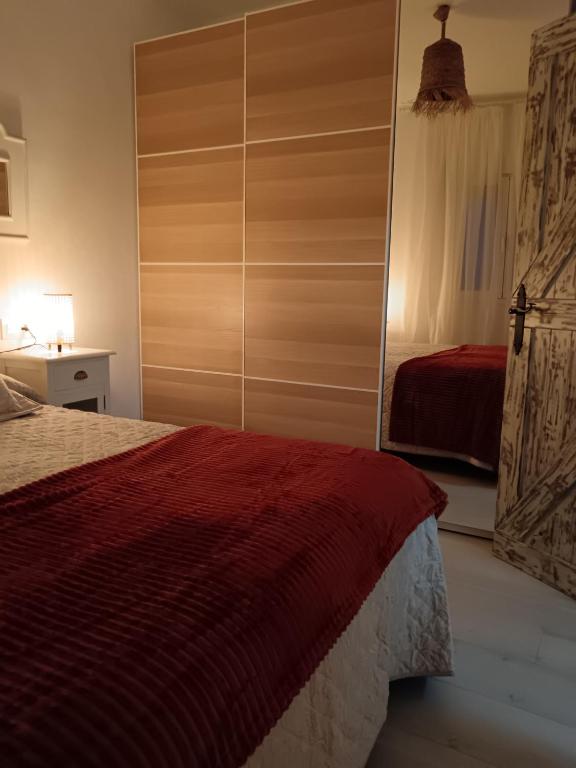 a bedroom with a bed with a red comforter at Casa Rural "Entre Costuras" in Setenil