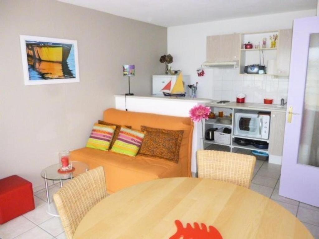 un salon avec une table et une cuisine dans l'établissement Résidence Argos - Location de Vacances - PORNICHET - 2 pièces - 021 - 60409 MAE-7411, à Pornichet