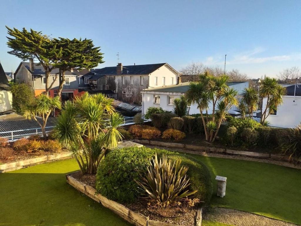 un train traversant une cour avec des palmiers dans l'établissement Résidence Le Galatée - Location de Vacances - PORNICHET - proche place du marché MAE-7421, à Pornichet