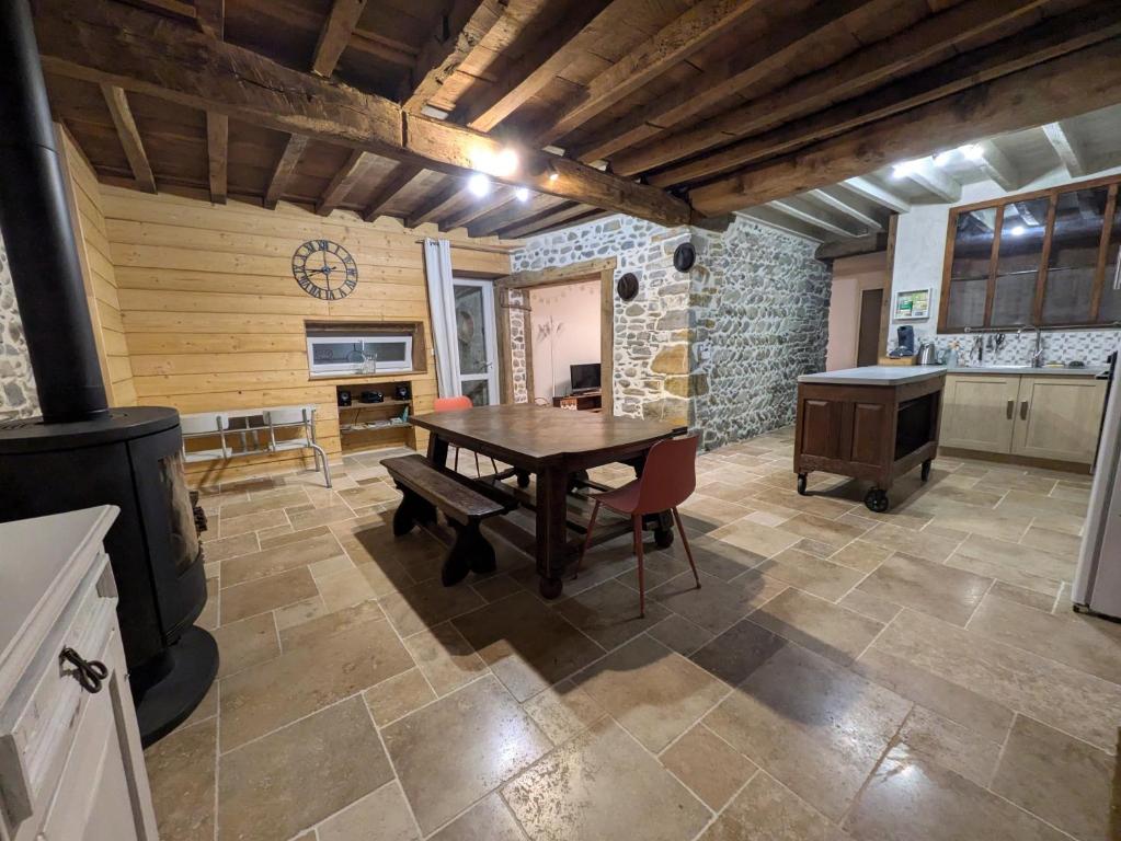 Il comprend une cuisine et une salle à manger avec une table en bois. dans l'établissement Les pierres qui parlent, à Précilhon