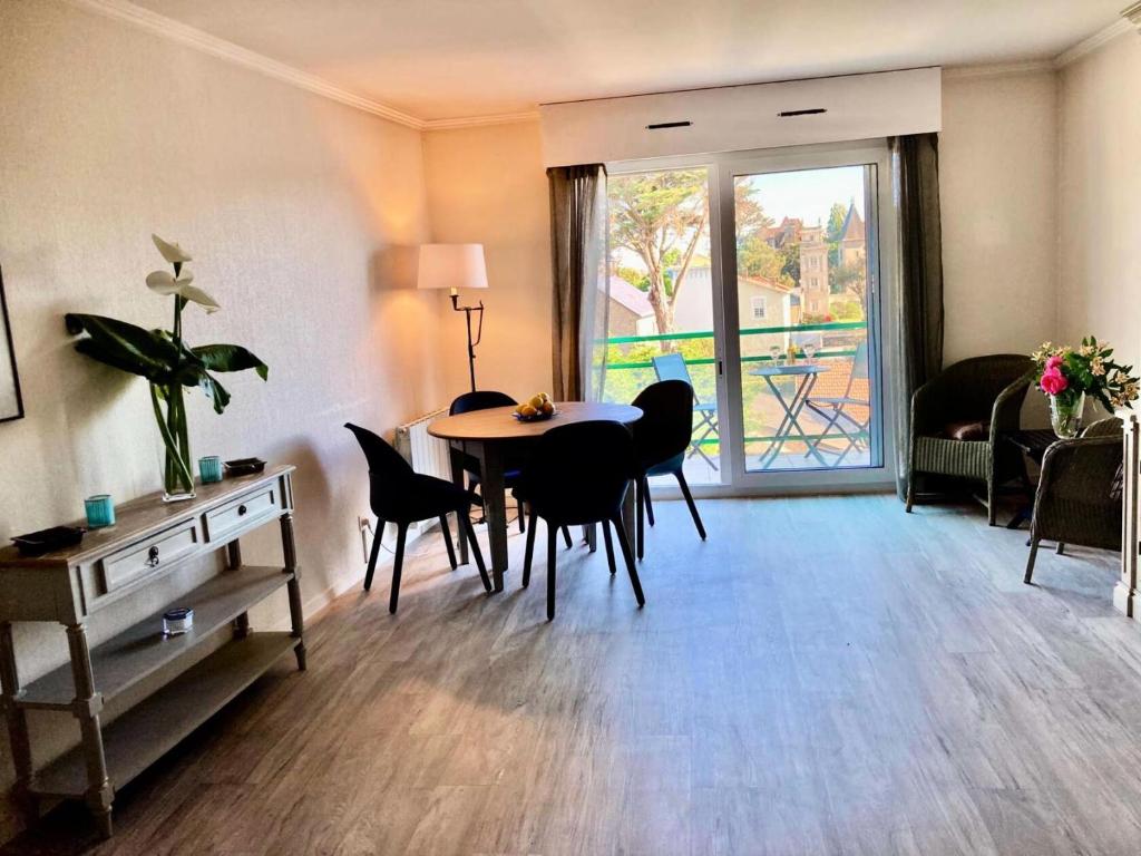 un salon avec une table et des chaises et une fenêtre dans l'établissement Résidence Le Brahms - PORNICHET - PROCHE PLAGE ET COMMERCES MAE-7521, à Pornichet