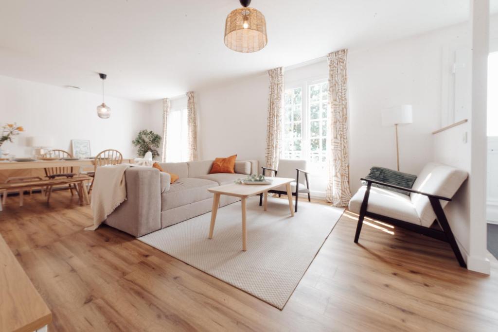 un salon avec un canapé et une table dans l'établissement Maison familiale avec jardin proche de La Rochelle, à Nieul-sur-Mer