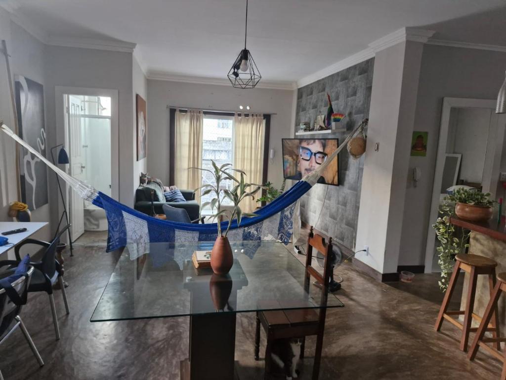 a living room with a glass table with a blue ribbon at Loft de Quarto e Sala em Vila in Belém