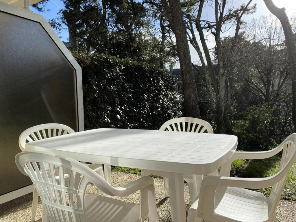 une table blanche et des chaises sur une terrasse dans l'établissement Résidence Le Gyserol - PORNICHET - Appartement 2 pièces à 200m de la plage pour 5 personnes MAE-0671, à Pornichet