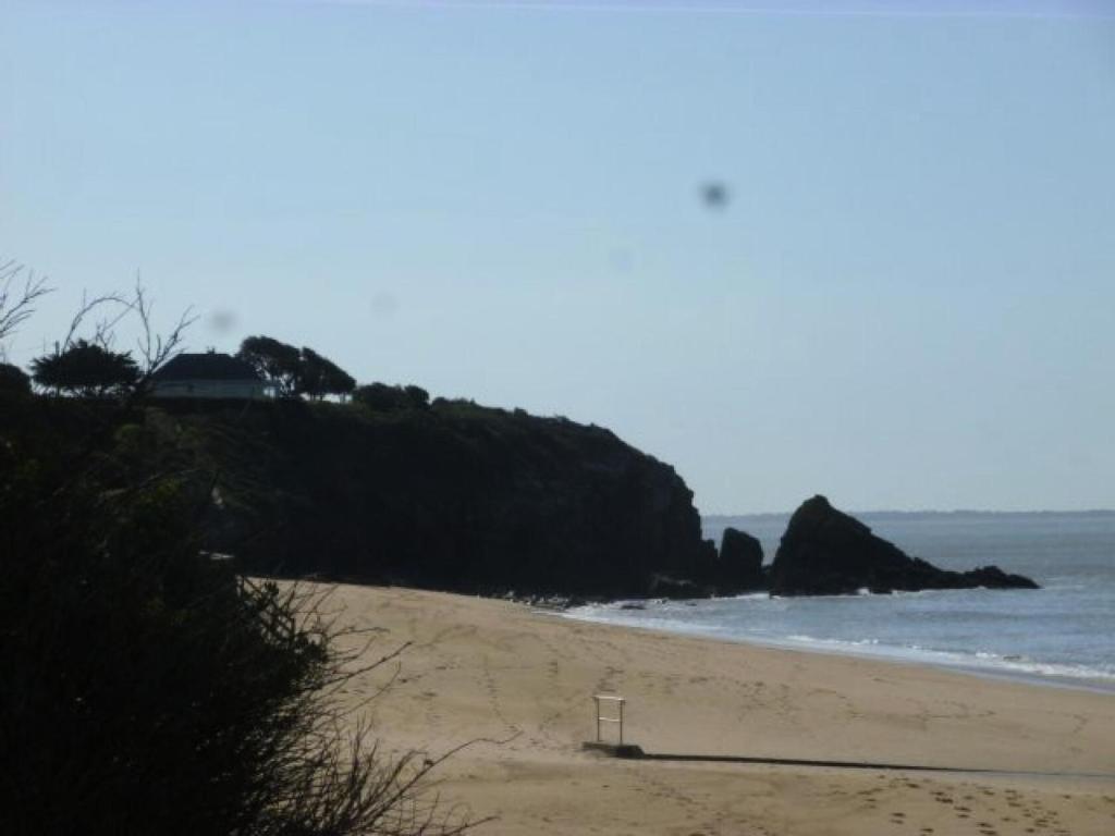 - une plage avec un banc dans le sable et l'océan dans l'établissement Résidence Nau-24-pornichet - Location de Vacances - PORNICHET - T3 FACE MER MAE-2911, à Pornichet