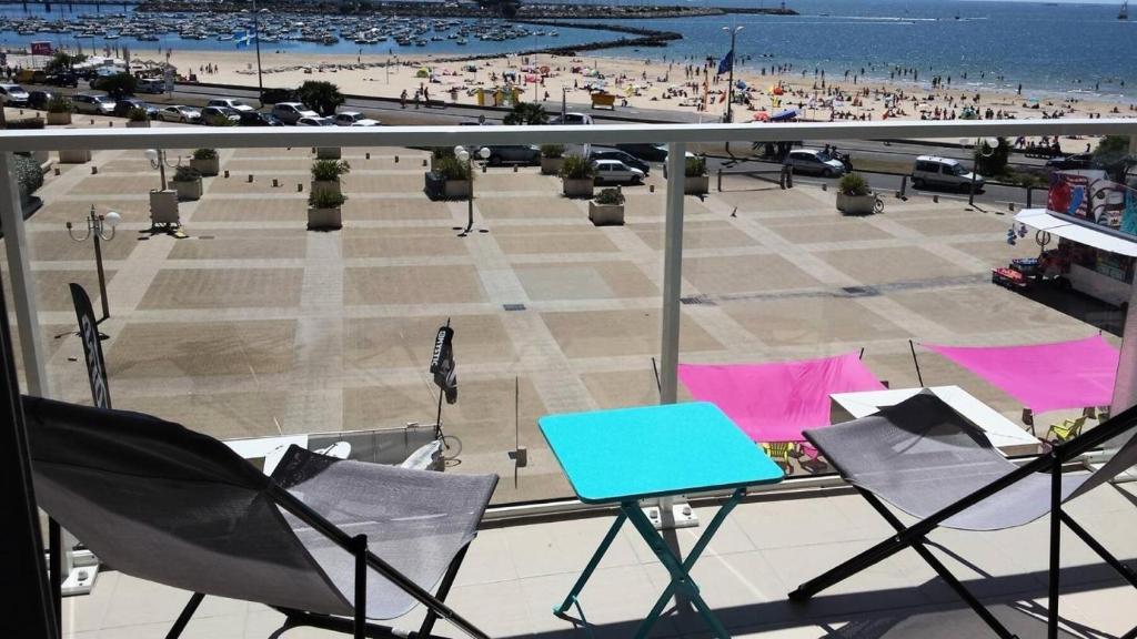 - un balcon avec des chaises, une table et une plage dans l'établissement Résidence Les Marines - PORNICHET APPARTEMENT FACE MER MAE-9681, à Pornichet