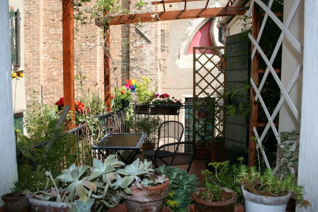 ヴェネツィアにあるVenezia Arsenale Biennaleの鉢植えの植物とテーブルと椅子が備わるパティオ