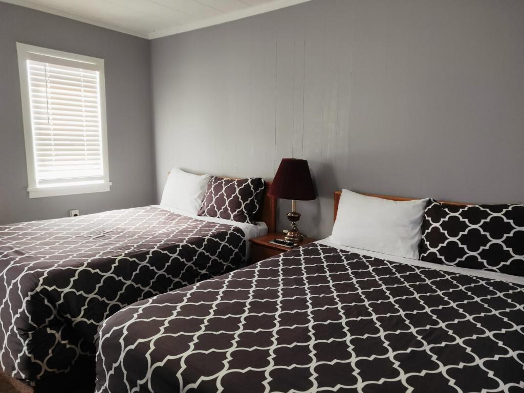 a bedroom with two beds and a window at Melsask Motel in Melville