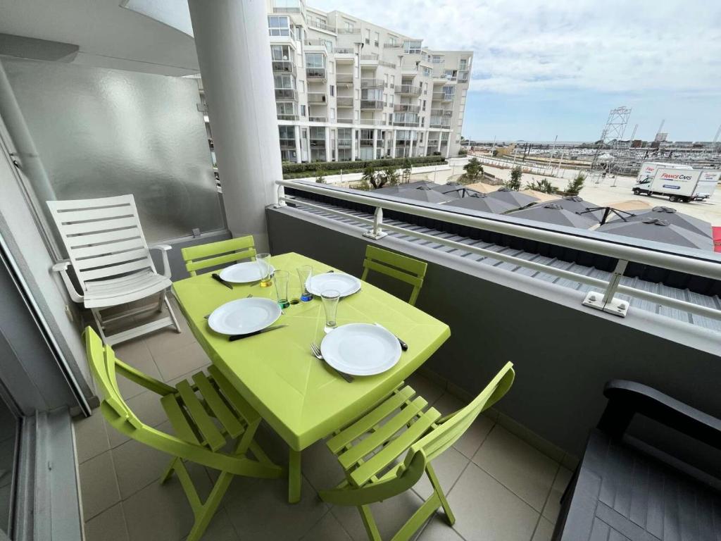 d'une table et de chaises vertes sur un balcon dans l'établissement Résidence Les Marines - PORNICHET APAPRTEMENT FACE MER MAE-8801, à Pornichet