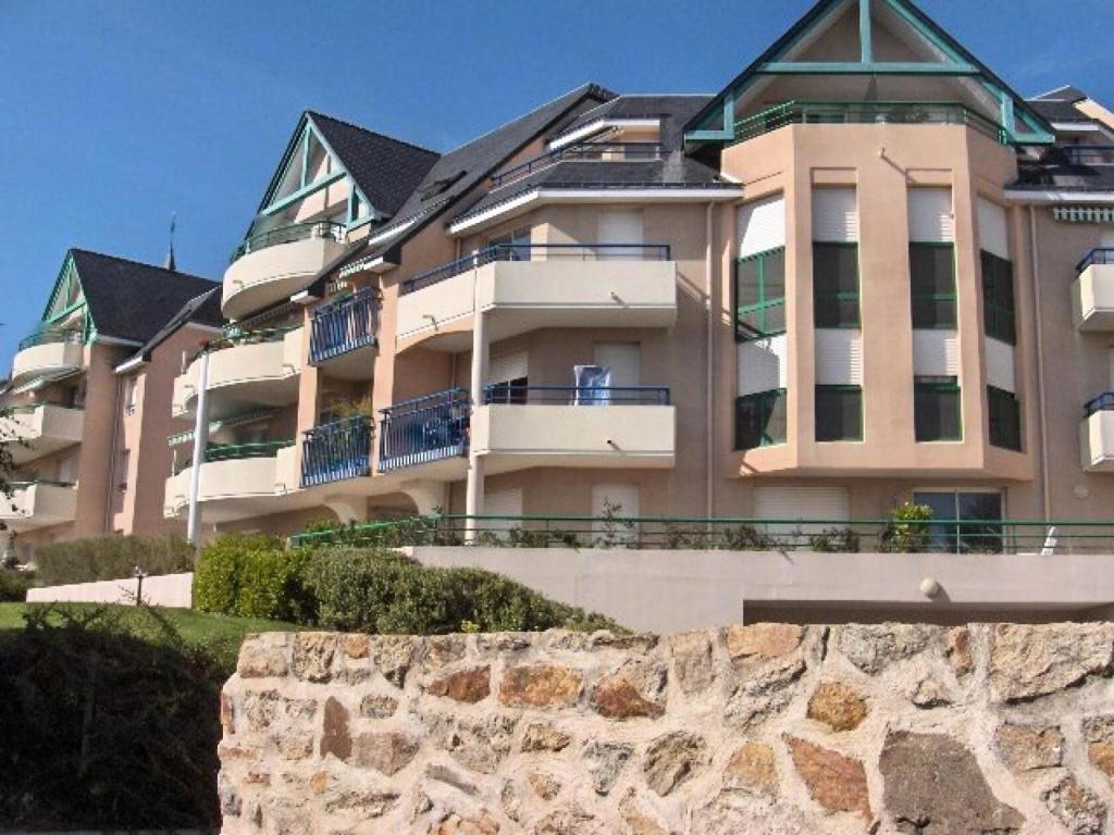 un grand bâtiment avec un mur en pierre devant lui dans l'établissement Résidence Alizée A - SAINT MARC SUR MER centre-ville proche Plage MAE-3561, à Géraud