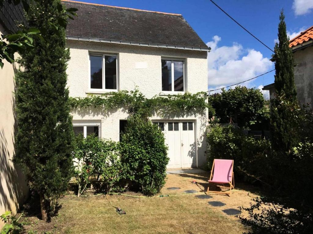 une chaise rose devant une maison blanche dans l'établissement Résidence Bonav-57-pornichet - Location de Vacances - PORNICHET - Villa 5 Pièces MAE-8321, à Pornichet