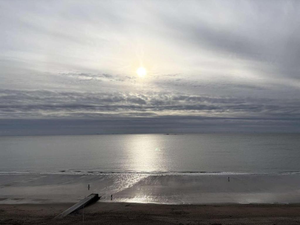 une plage au soleil brillant sur l'eau dans l'établissement Résidence La Louisiane - LA BAULE - IMMEUBLE EN VAGUES - FACE MER MAE-5181, à Mazy