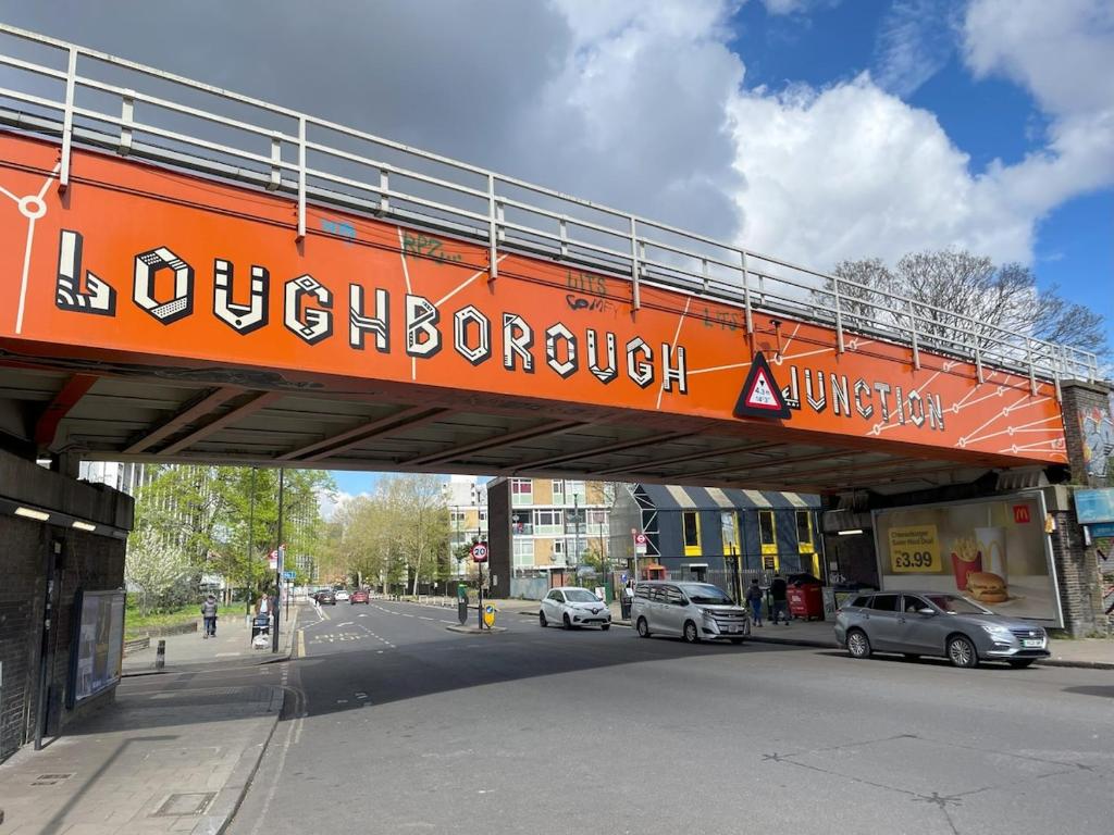 an orange bridge over a street with cars on the road at Stylish 2-Bed Garden Flat, 5 Mins to Brixton in London