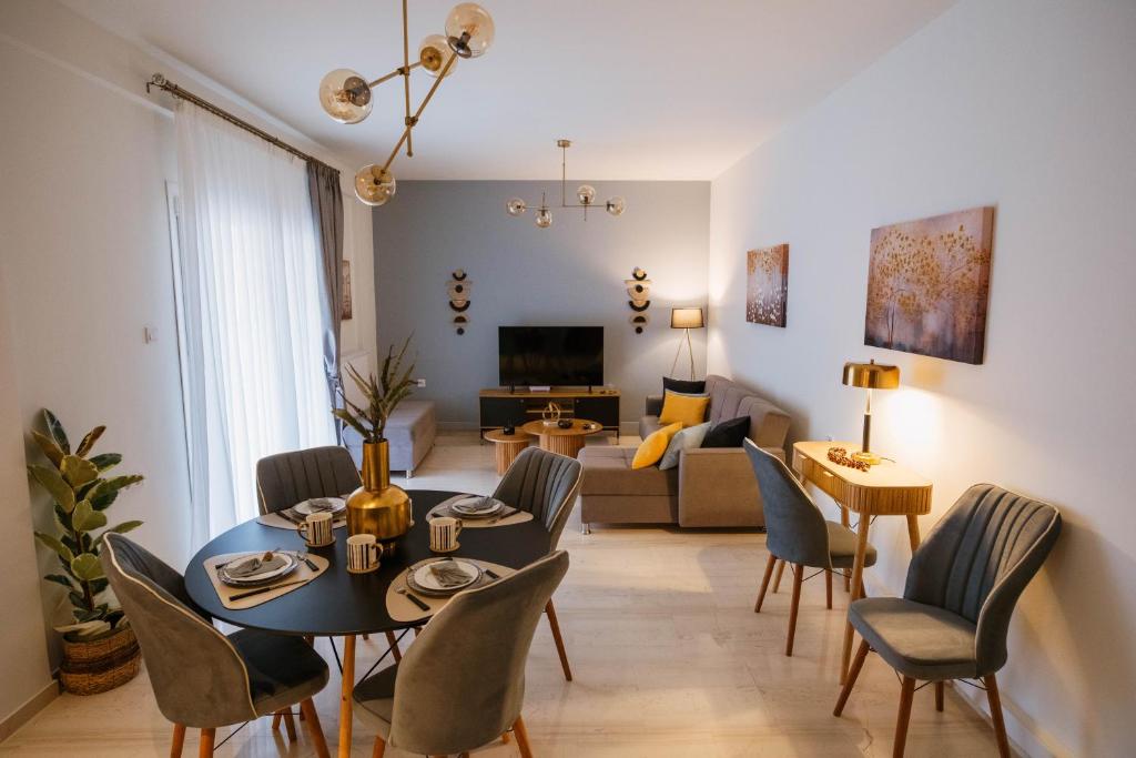 a living room with a table and chairs and a couch at DON Luxury Living Volos in Volos