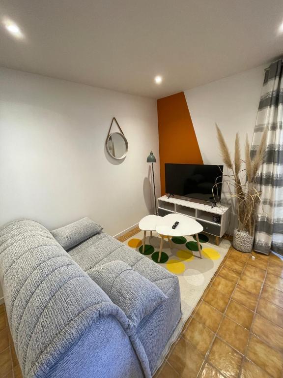 un salon avec un canapé bleu et une table dans l'établissement Studio indépendant Boulouris, à Saint-Raphaël