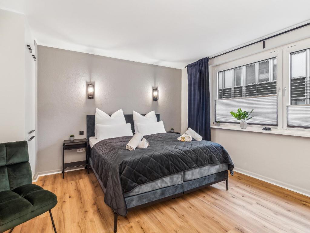 a bedroom with a bed and a chair and a window at Modernes 2 Zimmer Apartment mit Balkon, zentrale Lage in Bremen