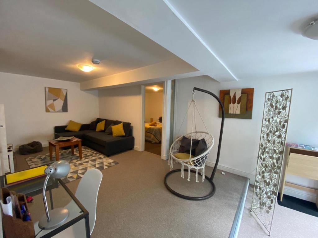a living room with a couch and a swing at The Hanham Retreat in Bristol
