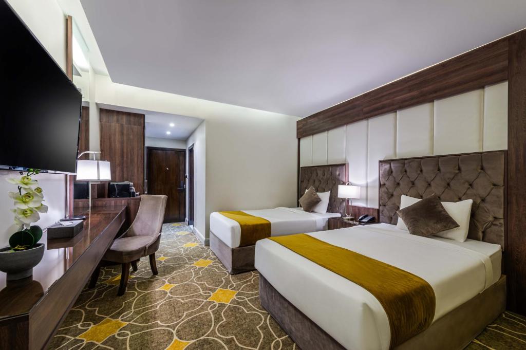 Postel nebo postele na pokoji v ubytování Abha Gardn Millennium Hotel