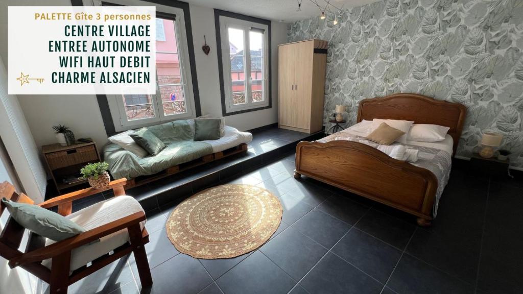 een slaapkamer met een bed, een bank en een tafel bij Gîte Petite Palette in Ribeauvillé