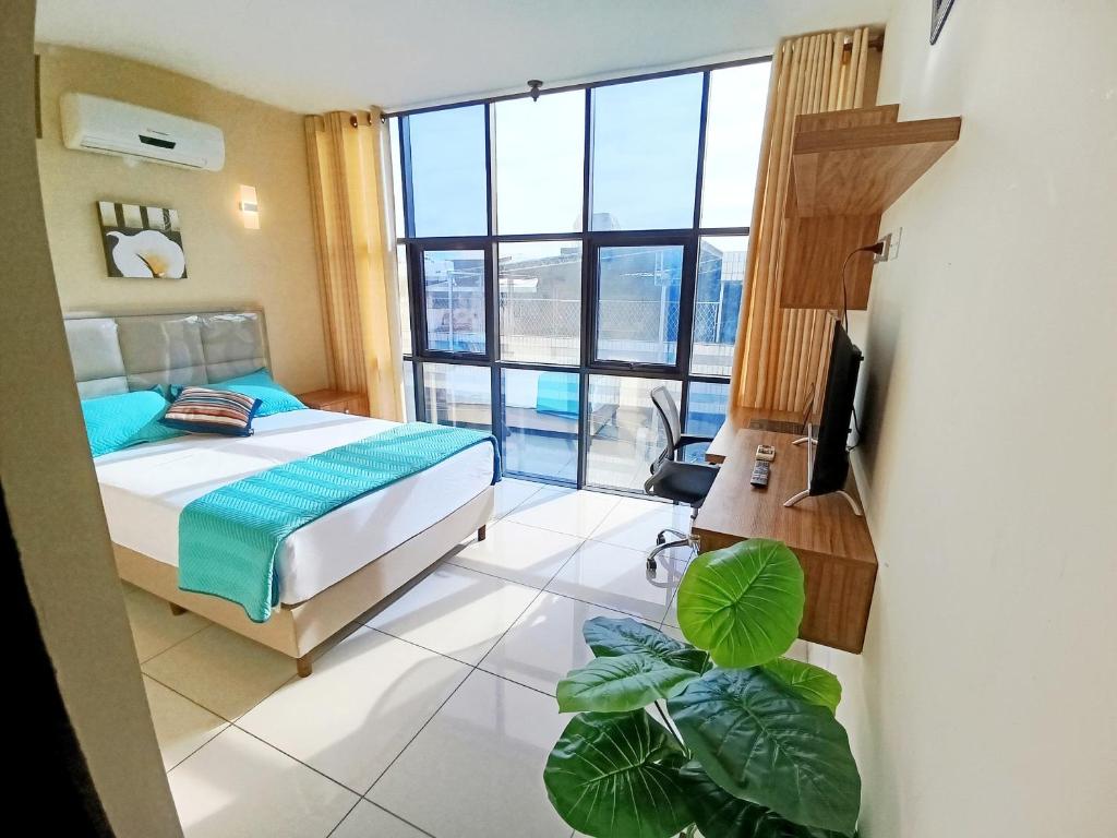 ein Schlafzimmer mit einem Bett und einem großen Fenster in der Unterkunft Centrico Espacio Cruceño Full in Santa Cruz de la Sierra