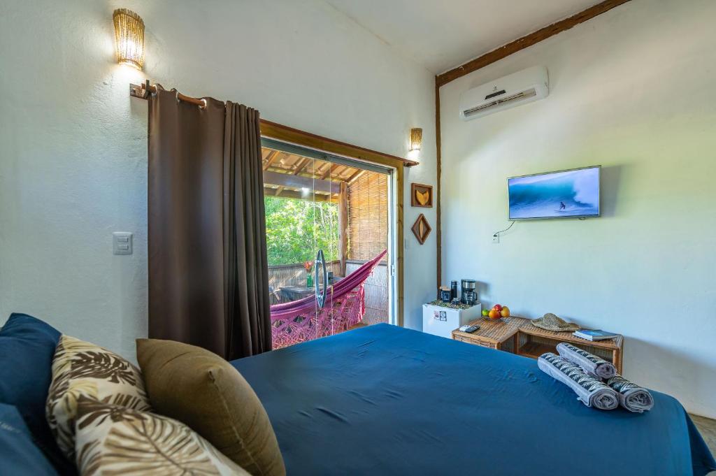 una camera da letto con un letto blu e una finestra di Bahia Soul - Kawai Suítes - Taipu de Fora - Península de Maraú a Marau