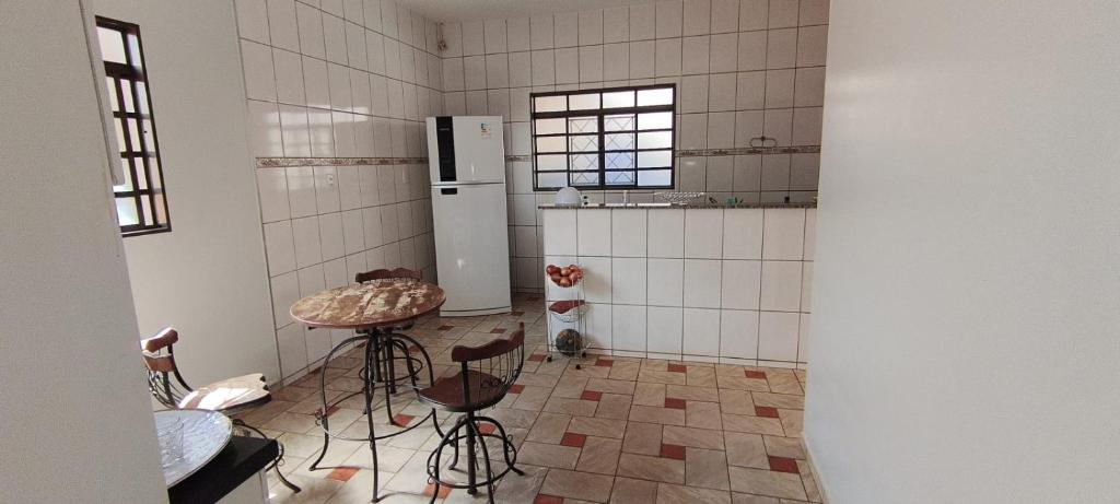 een keuken met een tafel, stoelen en een koelkast bij Casa para tecnoshow 2025 rioverde in Rio Verde
