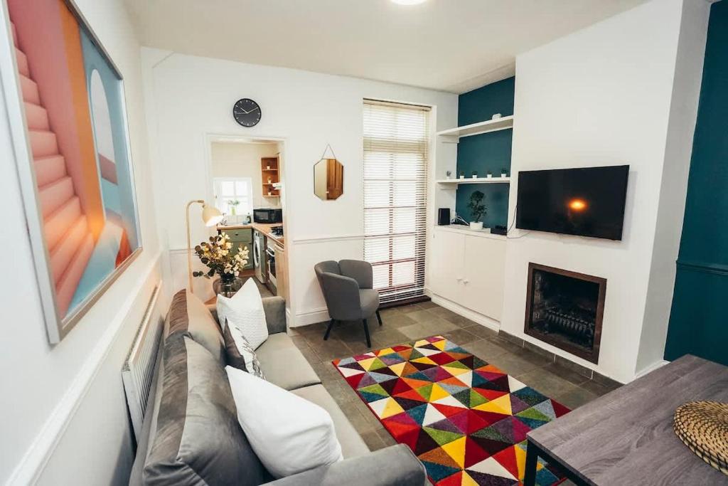 ein Wohnzimmer mit Couch und Kamin in der Unterkunft 4BR Town House, Self Check In, Parking, By DerBnB in Derby