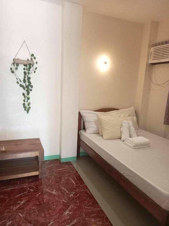 een kleine slaapkamer met een bed en een tafel bij Toto s House Junior Suite in Puerto Princesa City