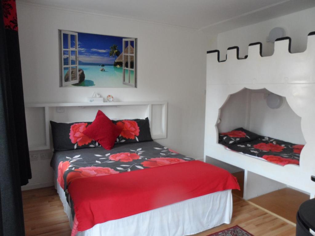 sypialnia z łóżkiem z czerwoną kołdrą w obiekcie Galway Guest House w mieście Weymouth