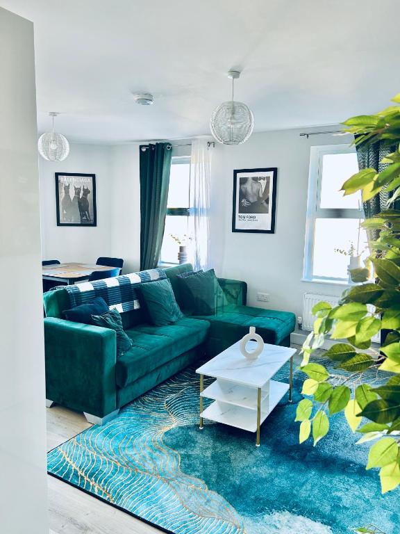 a living room with a green couch and a table at Folkestone Harbour Modern Comfortable Flat F3 in Folkestone