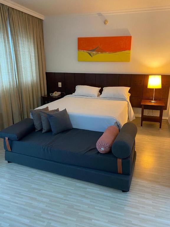 a bedroom with a bed and a blue couch at Flat Fabuloso Executivo 3 in São Paulo