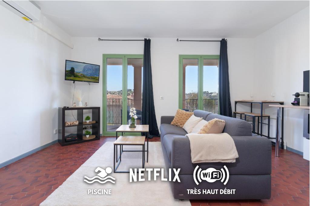 un salon avec un canapé et une table dans l'établissement Le Cali, Terrase, Parking, Piscine, Clim, à Villeneuve-Loubet