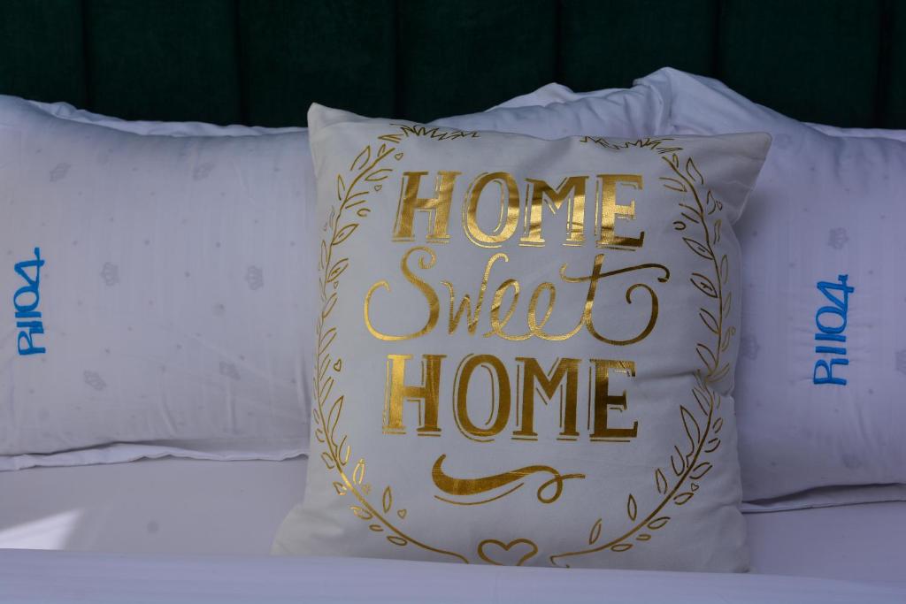 ein süßes Heimkissen mit einem Home Sweet Home Schild in der Unterkunft Simba Bnb Karen in Nairobi