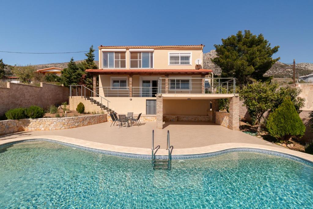 a house with a swimming pool in front of a house at Spacious Villa With a Pool in Nea Peramos
