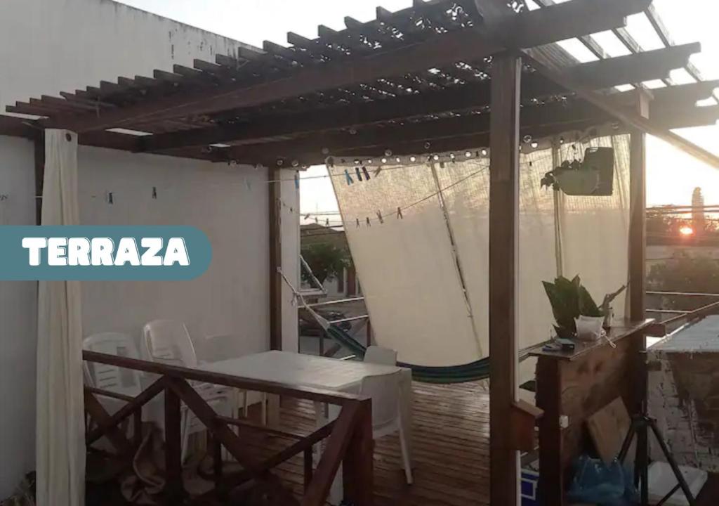 een patio met een tafel en stoelen en een pergola bij Moderno apto con terraza a cuadras del Shopping Terminal in Paysandú